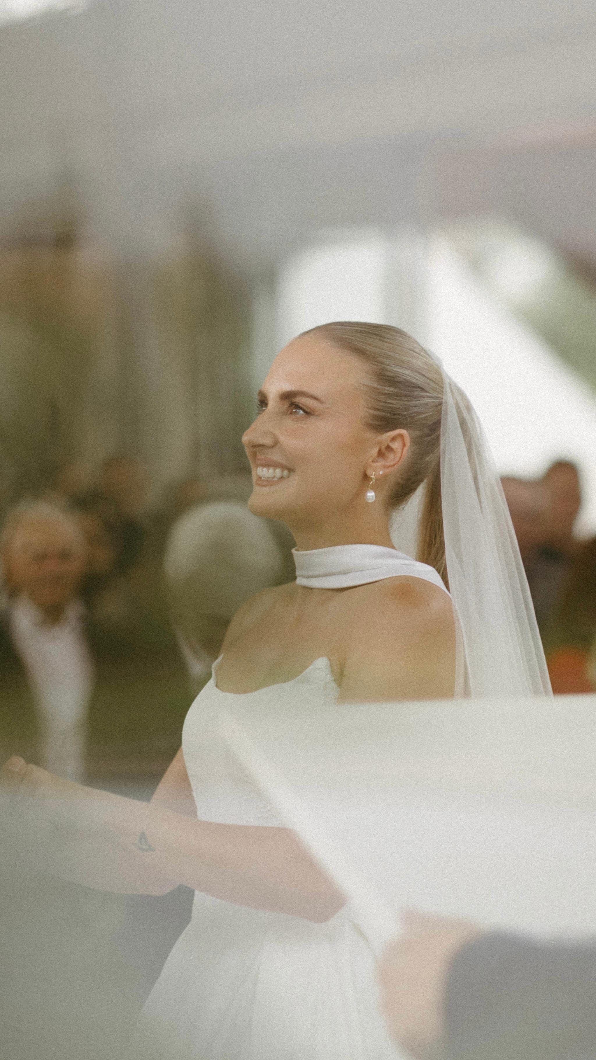 Bride smiling with flowing veil — radiant bridal makeup